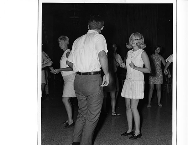 Young people dancing in a dark room