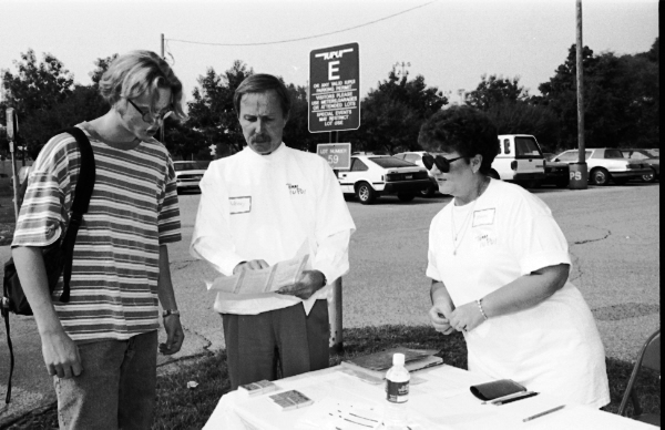 Older man and woman at a table showing a map to a young student