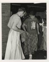 Two men looking down at the long skirts that they have on