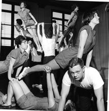 Group of students doing push-ups and other feats of strength on top of one another