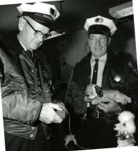 Two police officers playing with mechanical dogs