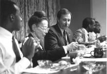 A man and woman, both college adminisrators, seated at a table. The man is looking at what the woman is eating