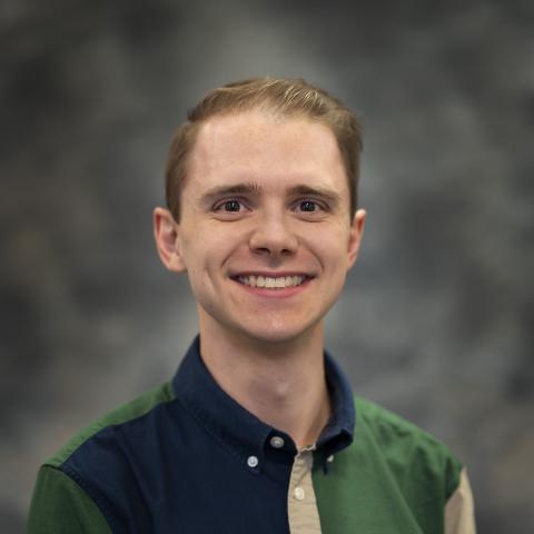 Smiling blonde man with dark brown eyes