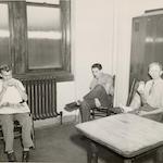 Three men eating lunch in a locker room